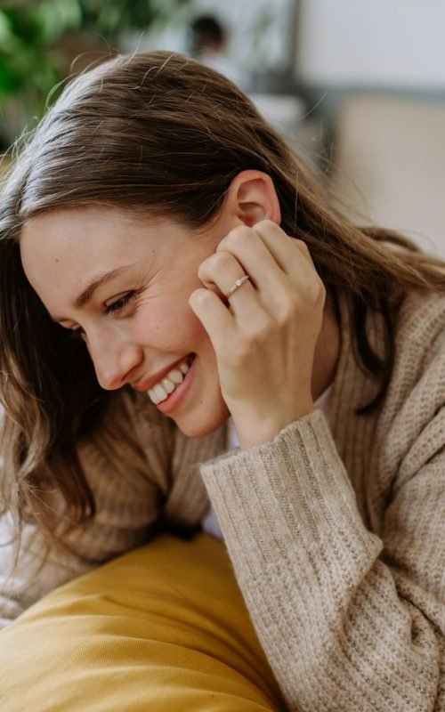 Young woman scrolling her smartphone in the apartment.